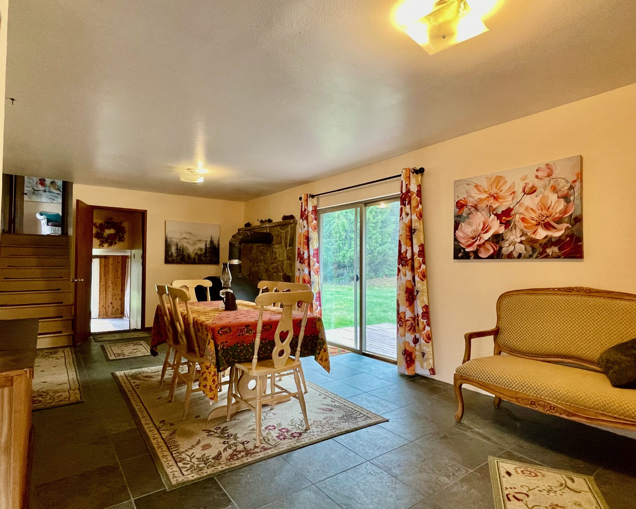 Looking the other direction with the sliding doors on the right there is another non-functioning wood stove and the stairs leading down to the lower level and up to the master suite.