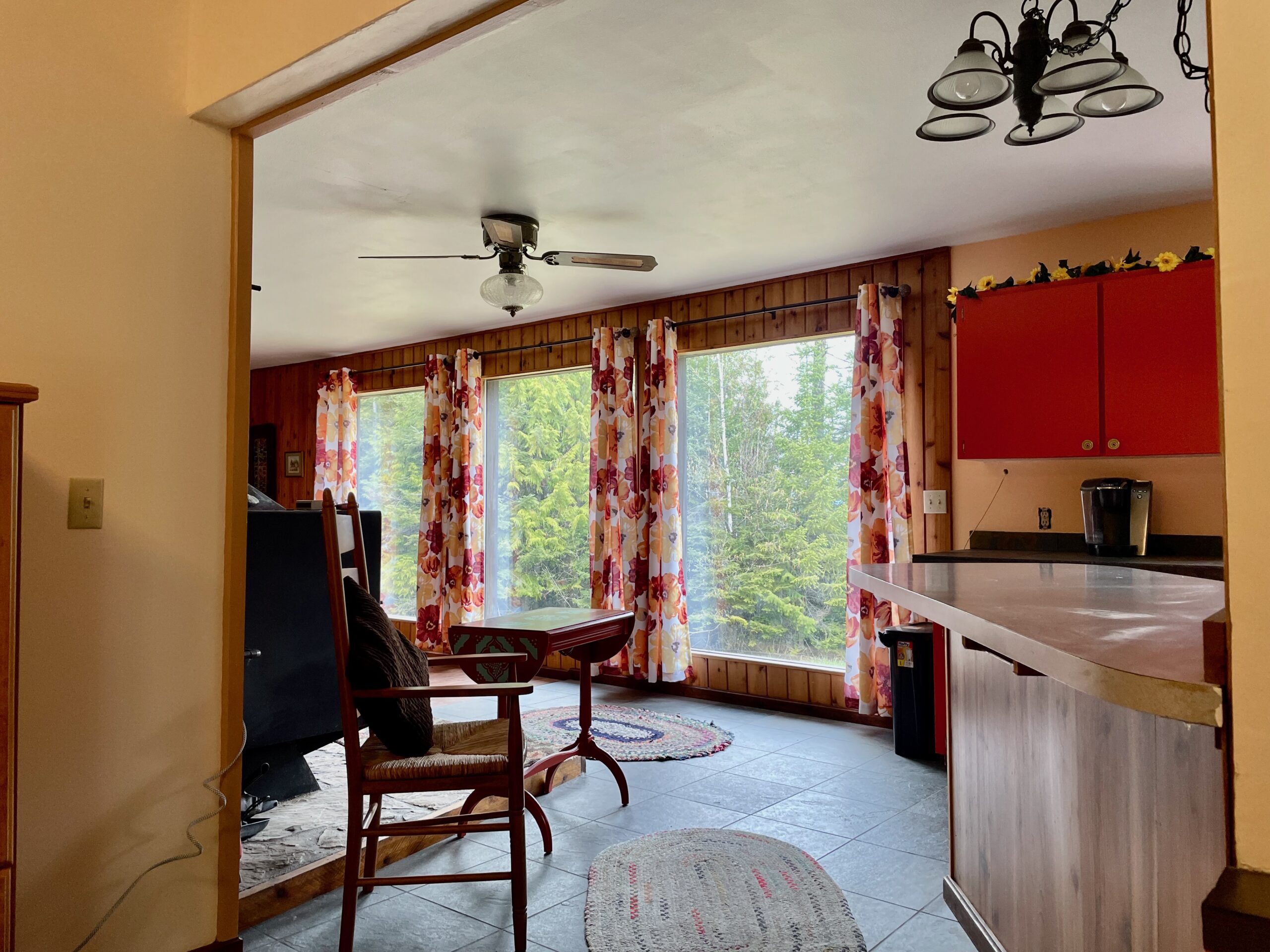 Turning around and to see the view of the pines out the 3 large windows between the kitchen and living room.