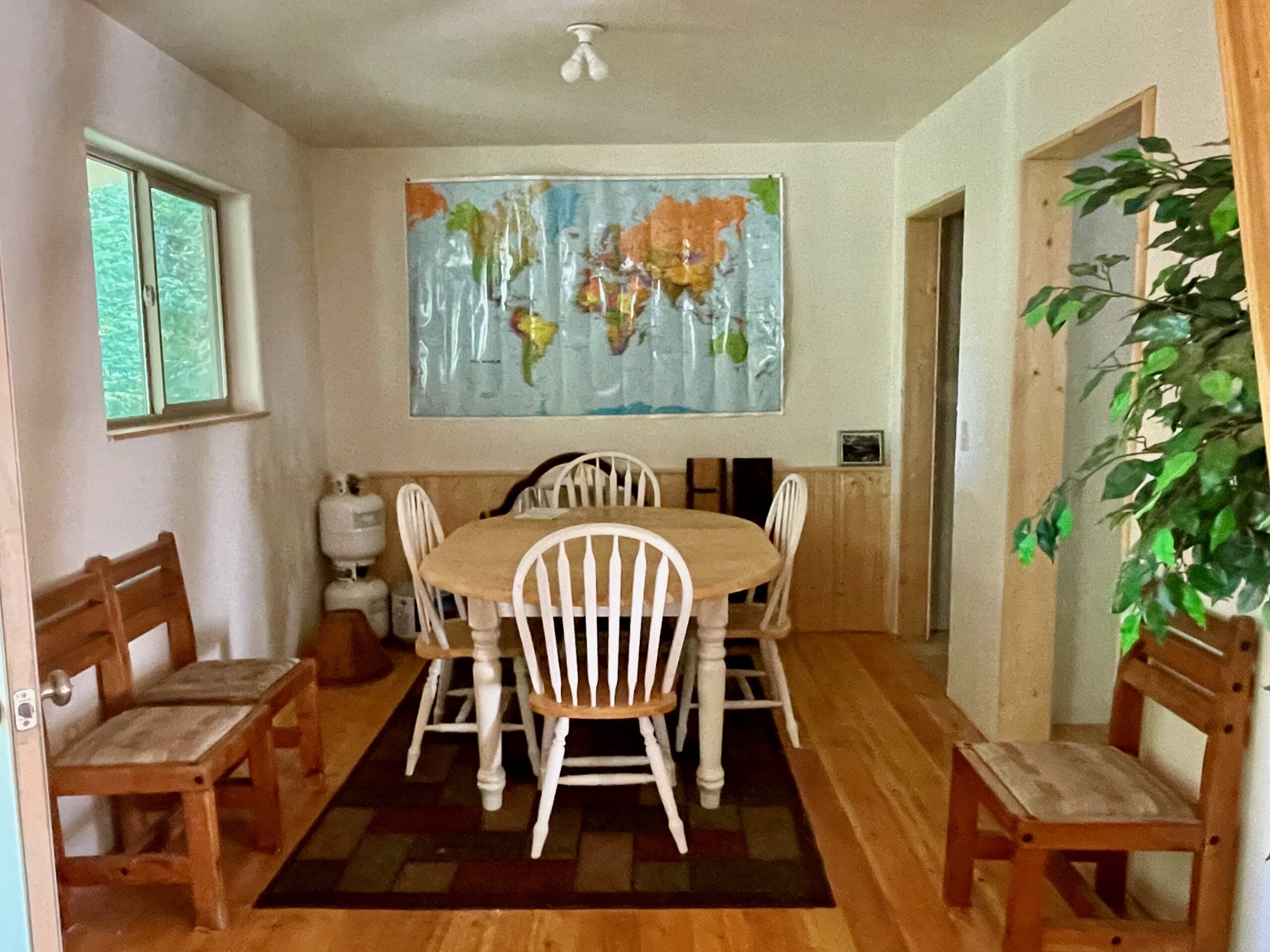 The dining room with a window and on the left a closet in the back and the entrance to the bathroom in the front.