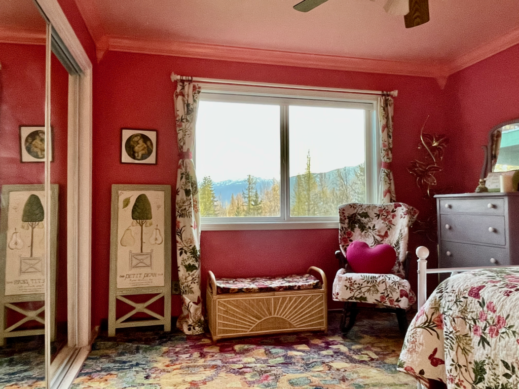 View of large window in bedroom as well as closet with glass sliding doors.