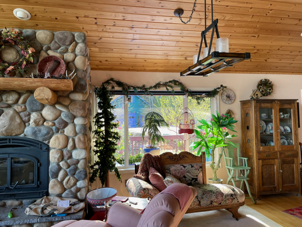 A view of the location for a dining room table with sun shining in through large front window.