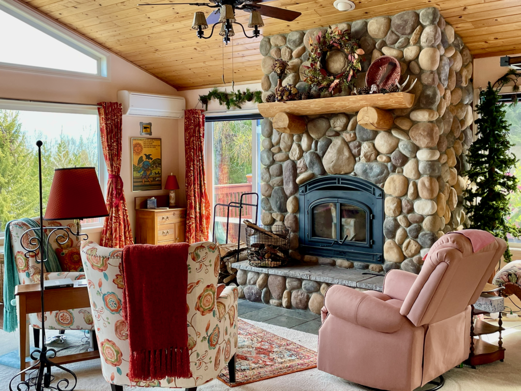 River rock fireplace with glass doors. The light salmon wall color highlights the color of the rocks. 