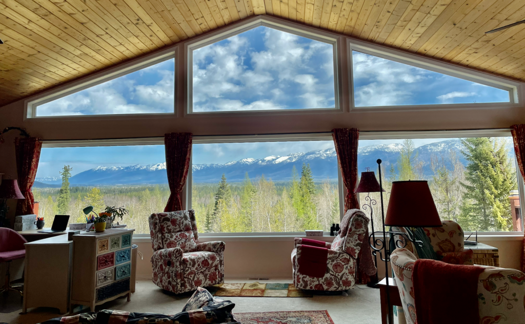 A view of the massive wall of windows in the great room and the panoramic view of the Swan Range.