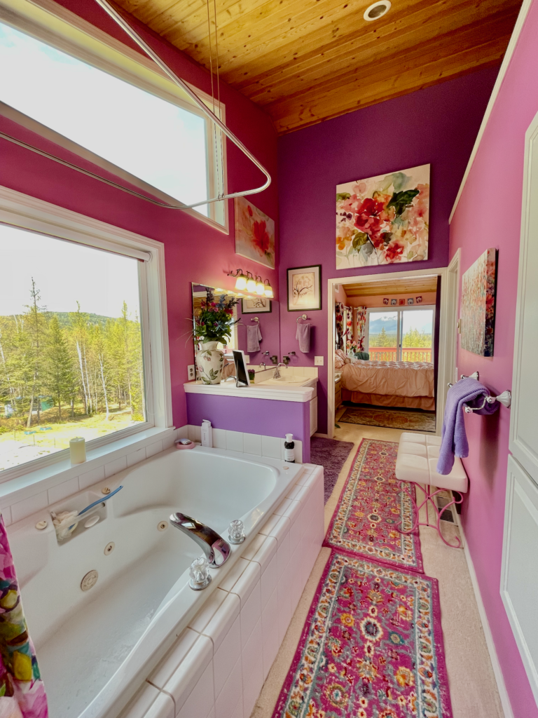 Looking from master-bath to the bedroom. The Swan Range can be seen out the sliding doors and Crane Mountain and the yard out the window beside the tub.