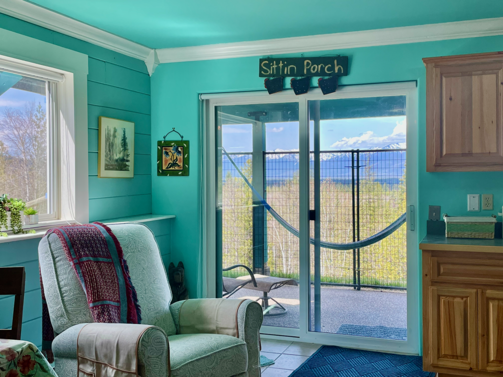 To the left of the kitchen cabinets is a sliding door out to a covered porch.