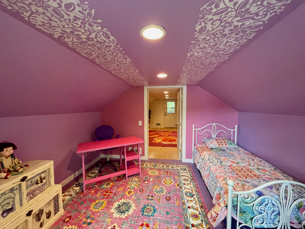 In the back is a room decorated for a girl's hangout or playroom. Room could have multiple uses.