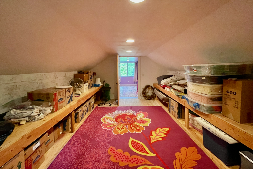 view entering rooms above the attached garage. The first room is a storage room with storage benches on each side.
