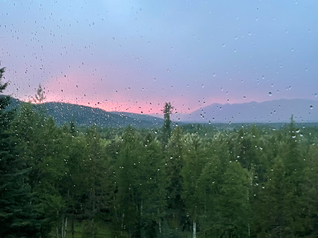 Pink and purple sunset off in the distance- near Whitefish and Glacier after a rain storm.