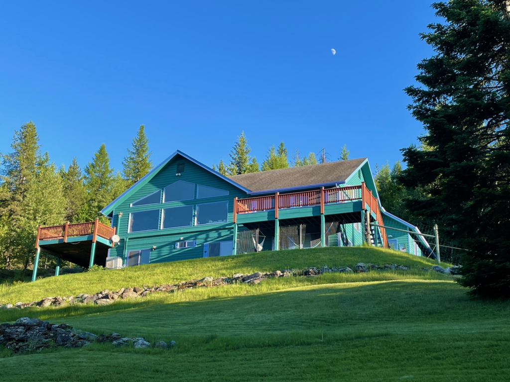 View of the back of the house including the master-deck stairs and garage in the far-right.