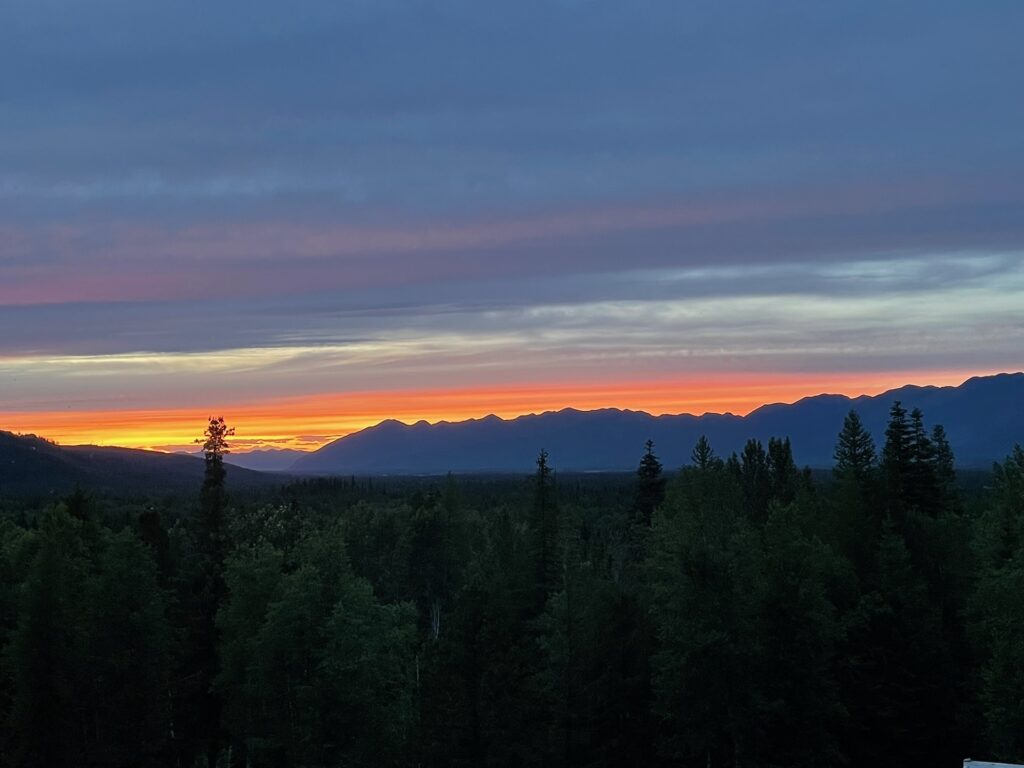 Page 10-A Few Final Notes A bright orange sunset with purple clouds above the Swan Range looking toward Glacier Park.