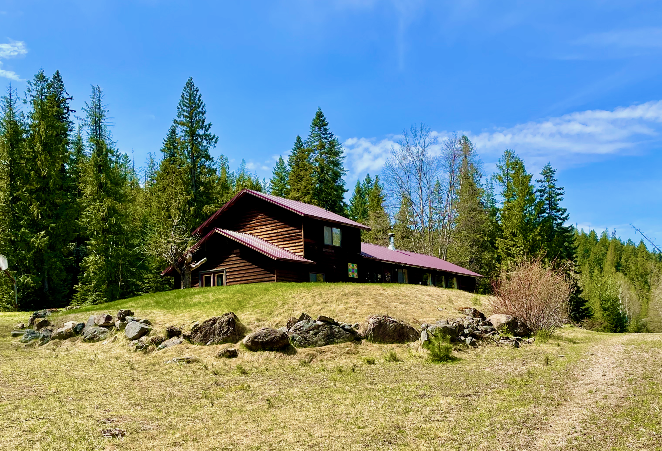 House surrounded by lawn and rock wall. View from Chintzey Lane.