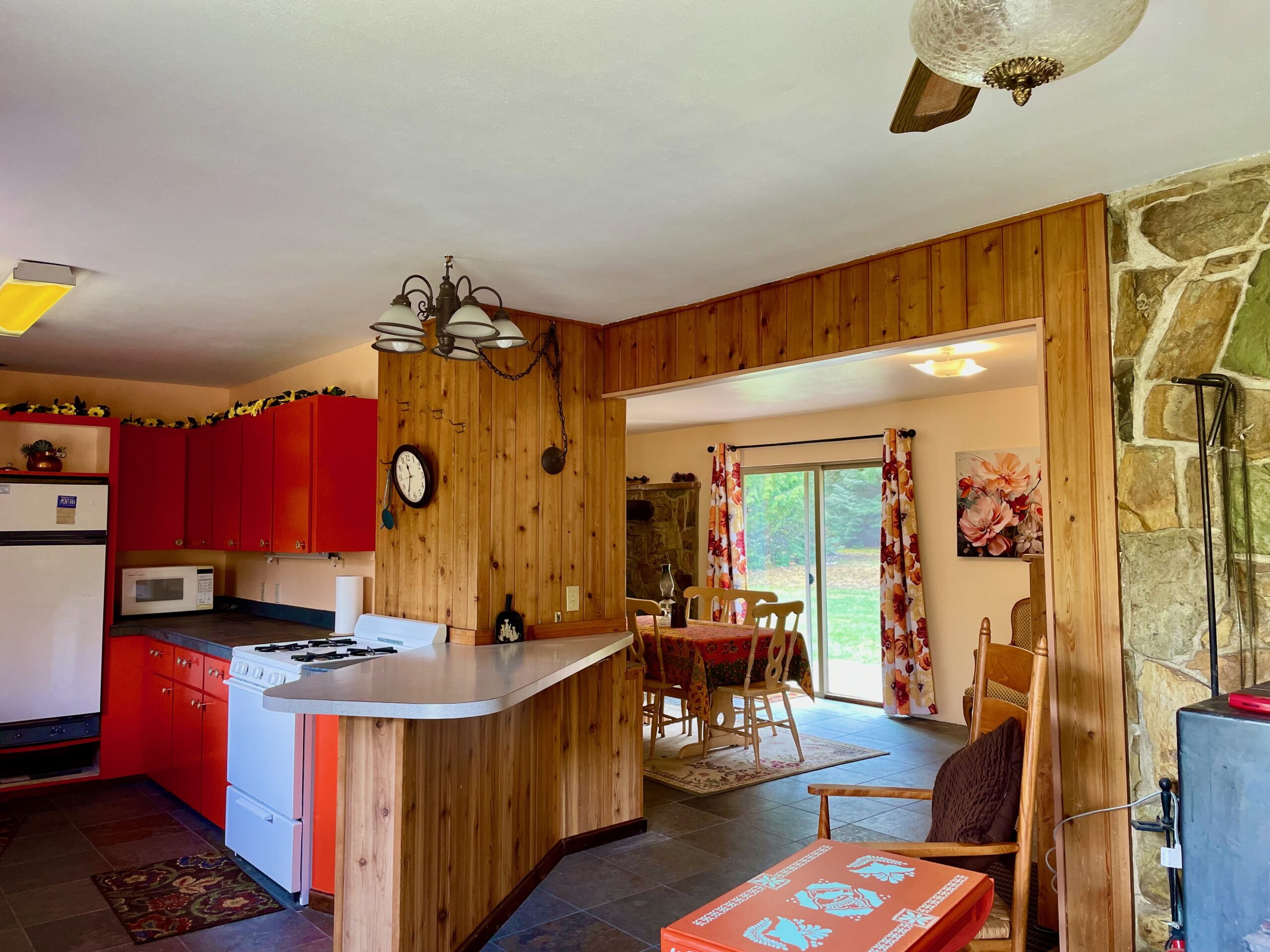 Turning to the right past the wood stove there is the kitchen bar on the left and a view of the dining room and sliding doors out to the backyard.