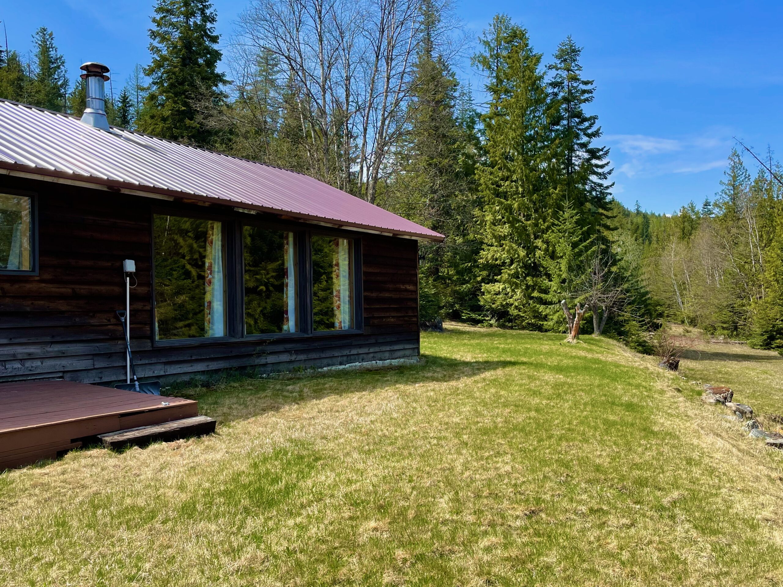 Big picture windows, metal roof and stained front deck. 
